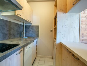 A compact kitchen with a built-in dishwasher, a sink, and a stove.