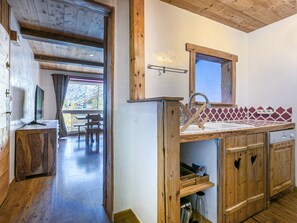 A wooden interior with a kitchen area, wooden cabinets, and a dining area with a view.