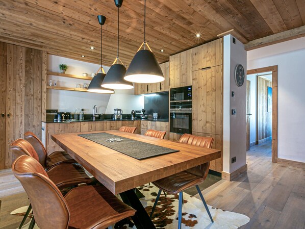 A modern kitchen with wooden cabinets, a large island, and stainless steel appliances. - Luxurious 3BR Apartment with Fireplace, Balcony & Mountain Views in Val-d'Isère (Val-d'Isère)