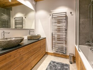 A modern bathroom with a wooden vanity, a large stone sink, a glass shower enclosure, and a towel rack. - Luxurious 3BR Apartment with Fireplace, Balcony & Mountain Views in Val-d'Isère (Val-d'Isère)