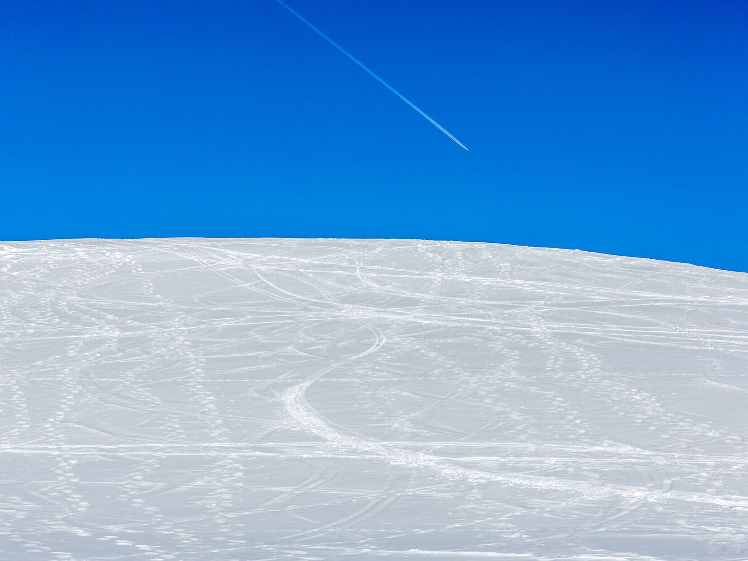 A snow-covered landscape with a clear blue sky.