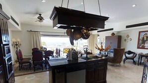 Cozinha moderna com ilha central, armários escuros e ventilador de teto.