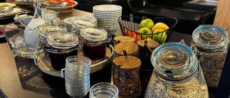 A buffet setup with various food items and condiments.