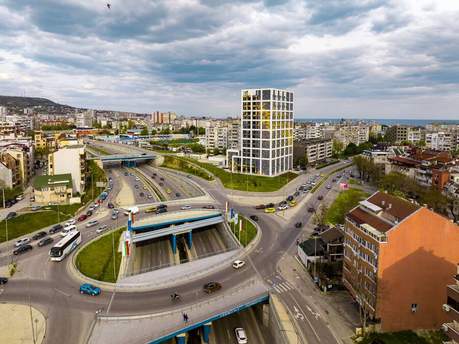Un nudo de autopistas con varios niveles y un edificio moderno con fachada de entramado.