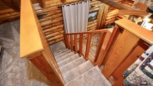 A wooden staircase with carpeted steps leading to a landing.