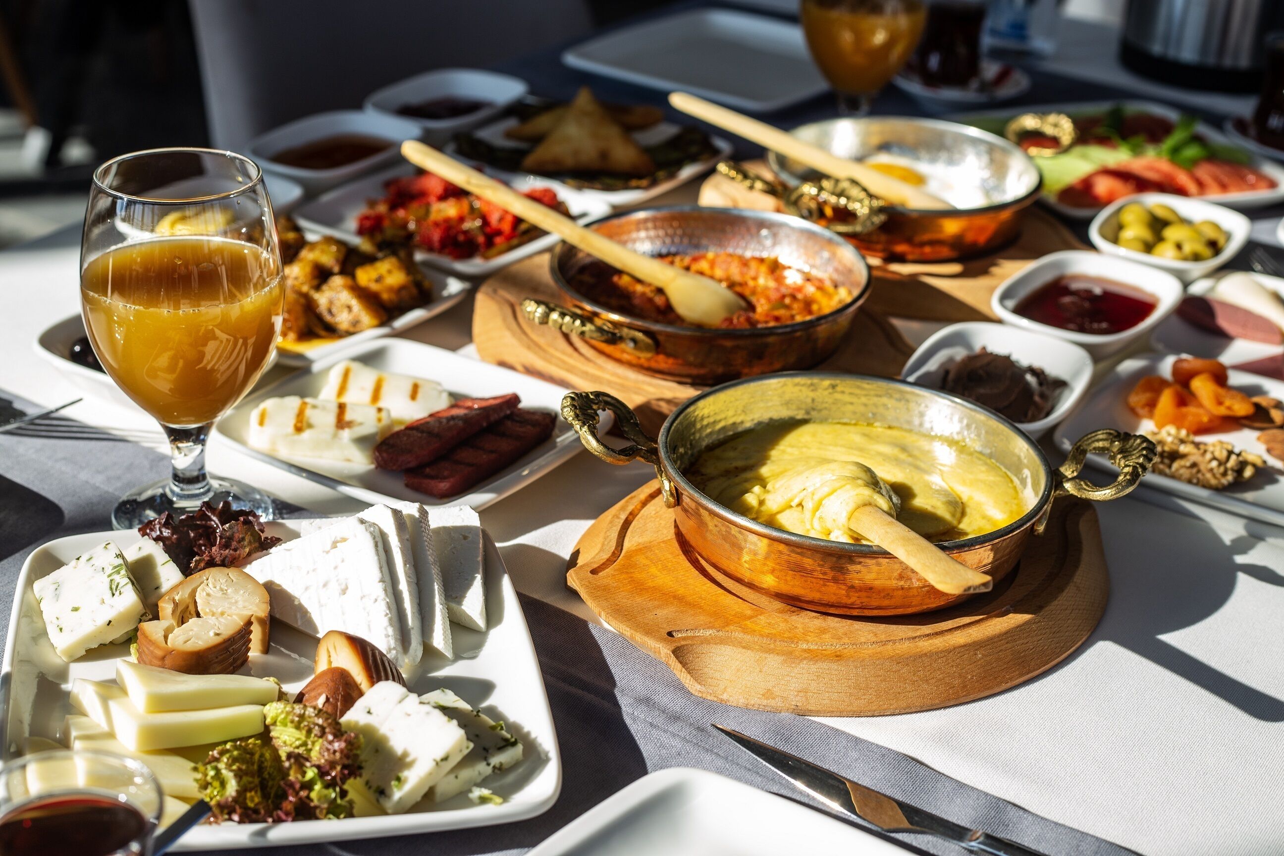 Ein Tisch mit verschiedenen Speisen, darunter Käse, Fleisch und einem Suppentopf.