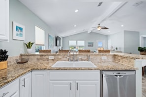 Enjoy cooking in this well-equipped kitchen with a large window offering a view of the outdoors.