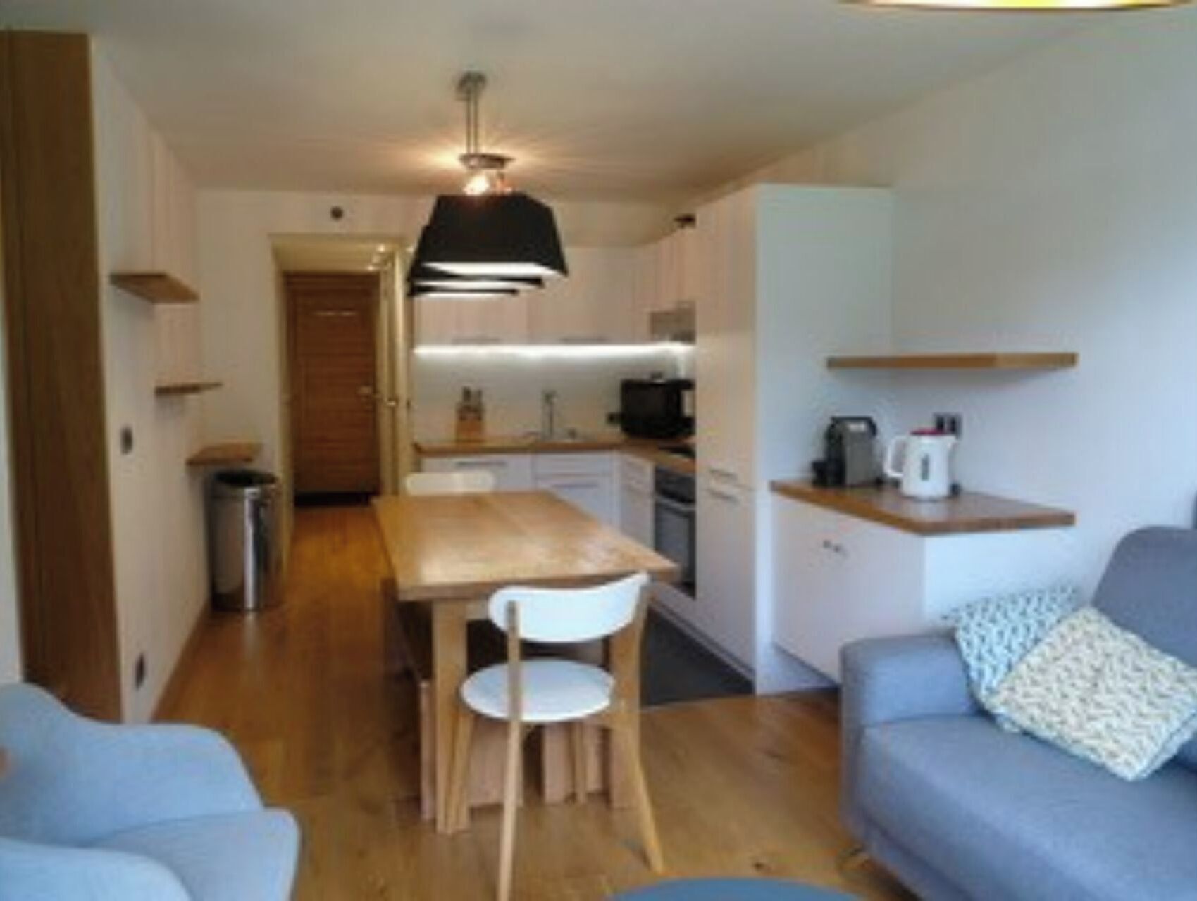 A compact living space with a kitchenette, a dining area, and a seating area.