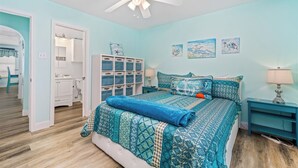 A bedroom with a bed, a ceiling fan, a nightstand, and a dresser. - Lunasea Haven by Miss Kitty’s (Rockport)