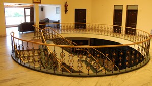 A circular staircase with ornate metal railings in a building. - Lotus Resort (Chhatrapati Sambhajinagar)