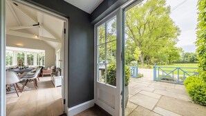 A modern kitchen with white cabinetry and a dining area with a large table and chairs. - Holmbush, Thornham, Norfolk (Thornham)