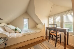 A bedroom with a loft bed, a wooden desk, and a chair. There are two windows with blinds, and a rug on the floor. - Holmbush, Thornham, Norfolk (Thornham)