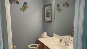 A bathroom with a toilet, sink, vanity, and decorative wall stickers. - Beach Block Beauty with Ocean Views (Wildwood)
