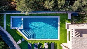 A rectangular swimming pool with a surrounding grassy area and a stone pathway leading to it. - Villa Moreta with heated pool, Sauna, Hot-tub (Okrug Gornji)