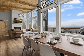 Enjoy meals in this spacious dining area with a large table, fireplace, and views of the outdoors.
