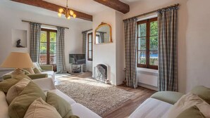 Ein gemütliches Wohnzimmer mit Kamin, Fernseher und Sofa.