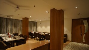 A conference room with a long table, chairs, and a wooden reception desk. - Hotel Mumbai House Express (Udaipur)