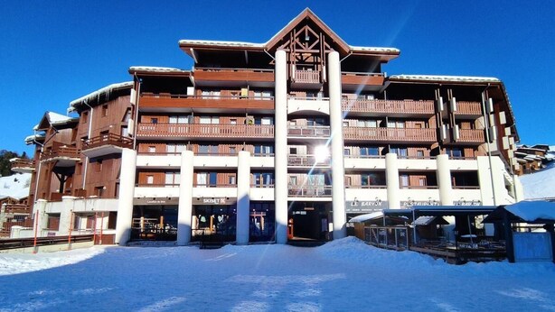 Ein mehrstöckiges Hotel mit Balkonen, einer Seilbahn und einem Restaurant.