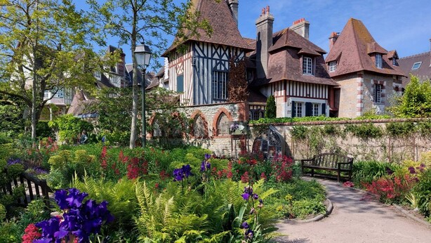Un bâtiment historique doté d’un jardin dont un chemin mène à l’entrée.