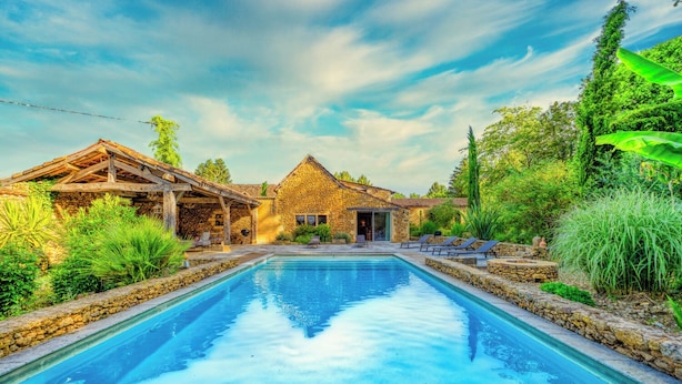A pool surrounded by stone walls and a stone building with a thatched roof. - Dezie Manor Grange and Gardens near Sarlat la Caneda (Val de Louyre et Caudeau)