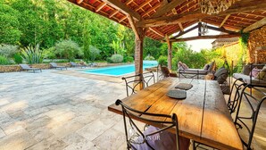 A covered outdoor area with a pool, stone flooring, and wooden furniture. - Dezie Manor Grange and Gardens near Sarlat la Caneda (Val de Louyre et Caudeau)