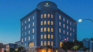 A modern hotel with a curved facade, multiple windows, and a prominent logo at the top. - Gran Palette Hakodate (Hakodate)