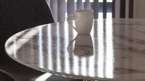 A round table with a white mug on it, positioned near a window with vertical blinds. - 2BR Apartment near Ashford Town | Balcony & WiFi (Ashford)