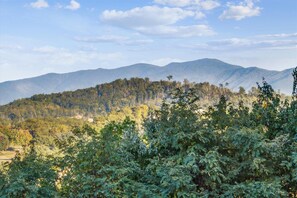 A mountainous landscape with dense forest in the foreground and a clear sky. - Whispering Pines 124 by Jackson Mountain Rentals (Pigeon Forge)