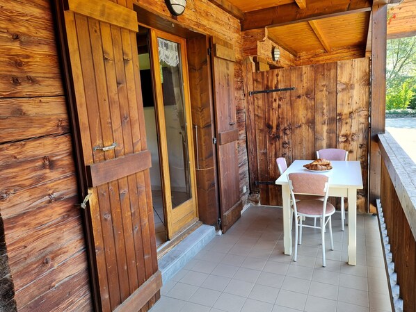 Une cabane en bois dotée d’un coin repas comprenant une table et des chaises.