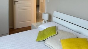 Une chambre à coucher comprenant un lit, une table de chevet, une lampe et un appareil de climatisation.