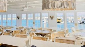 A restaurant with white walls, large windows, and hanging light fixtures. - Manly Oasis, 5bd, 3 King bd,Pool (Manly)