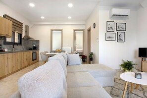 A modern apartment with a kitchen, living room, and dining area.