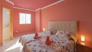 A bedroom with two beds, a window, a door, and a bedside table with a lamp. - Clemente House, Private Pool – Sea Views, Private Terrace, and Wi-Fi (arafo)