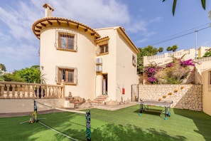 A two-story building with a tennis court, a pool table, and a stone wall with plants. - "Villa Rafael" with Sea View, Pool & Wi-Fi (El Poble Nou de Benitatxell)