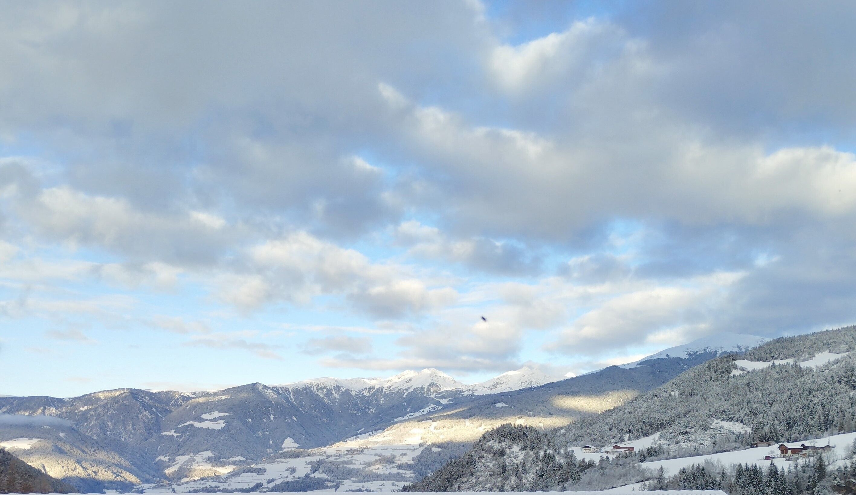 A mountainous landscape with snow-covered peaks and a valley.
