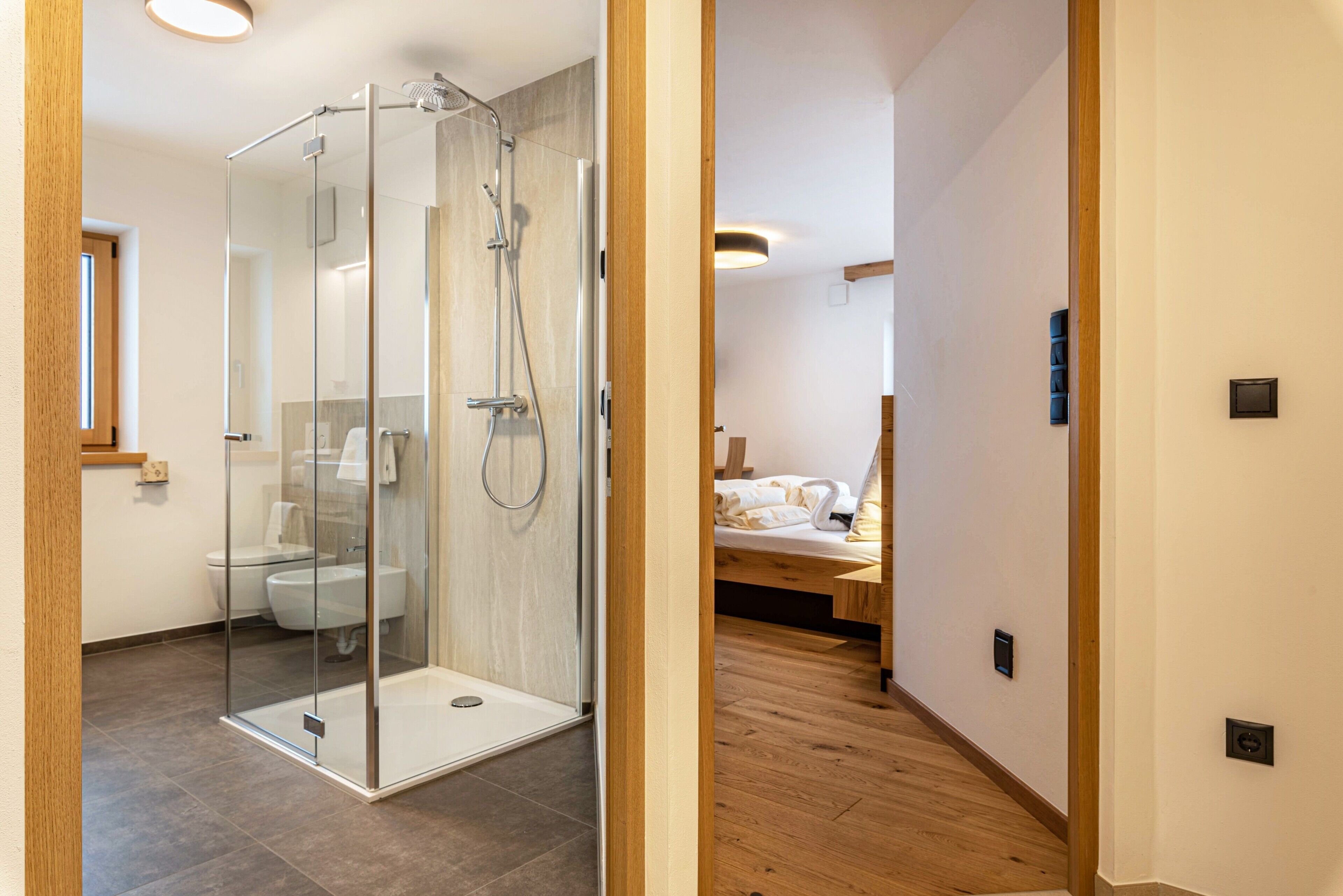 Un bagno moderno con doccia vetrata, servizi igienici e lavandino.