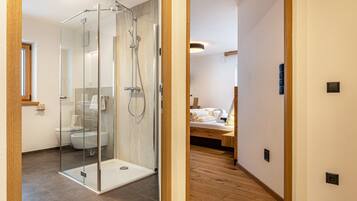 Un bagno moderno con doccia vetrata, servizi igienici e lavandino.