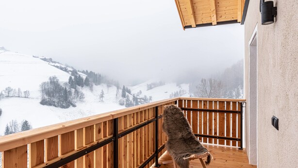 A wooden balcony with a view of a snowy landscape. - Holiday Apartment "Planerhof Apartment Lilie" with Mountain View, Shared Terrace and Wi-Fi (Funes)