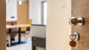 A door with a keyhole and a keyring with a wooden keychain. - Holiday Apartment "Planerhof Apartment Lilie" with Mountain View, Shared Terrace and Wi-Fi (Funes)