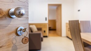 A wooden door with a keyhole and a keychain with a logo. - Holiday Apartment "Planerhof Apartment Alpenrose" with Mountain View, Shared Terrace, and Wi-Fi (Funes)