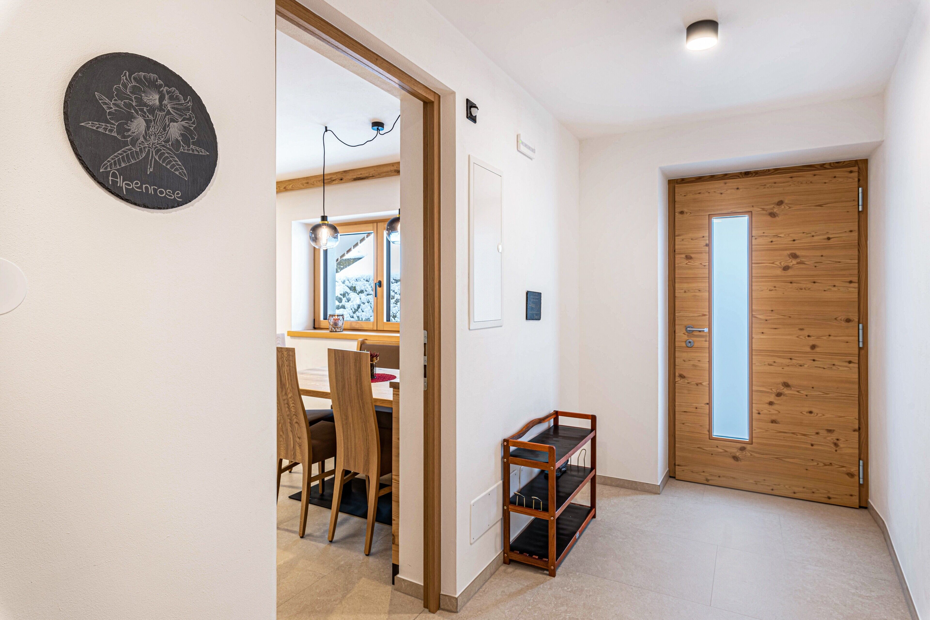 Ein Flur mit einer Holztür, einem kleinen Regal und einem an der Wand befestigten Schild.