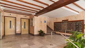 A lobby with marble flooring, wooden beams, a staircase, and a wall with a filing system. - Holiday Apartment "Amador" with Sea View, Pool & Garden (Algarrobo-Costa)
