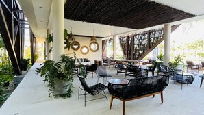 An outdoor seating area with modern furniture, a pergola, and hanging lights. - TULUM loft in the Heart of Aldea Zama (Tulum)