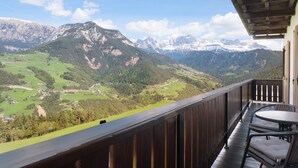 A balcony with a view of a mountainous landscape, a wooden railing, and a table with chairs. - Apartment 'Rosengartenblick' with Terrace, Balcony and Wi-Fi (Steinegg)