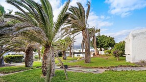 A landscaped area with palm trees, a pathway, and a white building. - Holiday Apartment "Poris" with Heated Pool, Private Terrace & Wi-Fi (Arico)