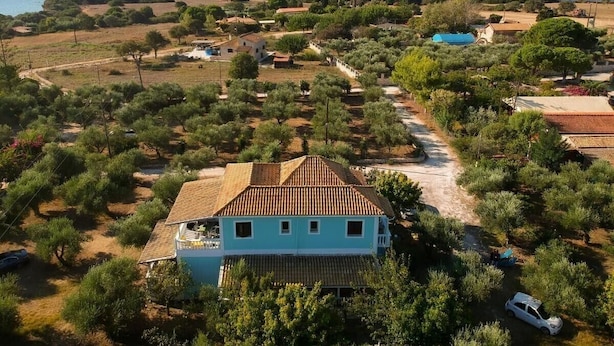A coastal property with a prominent house, a swimming pool, and surrounding vegetation.