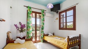 A room with two beds, a TV, and a window with a view.