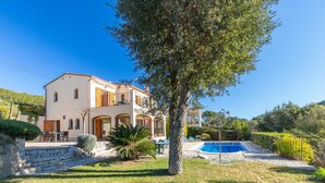 A two-story house with a swimming pool, outdoor furniture, and a tree. - Villa "Rosa" with Mountain View, Pool & Wi-Fi (Calonge)