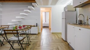 A modern kitchen with white cabinets, a wooden countertop, and a built-in oven.