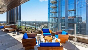 Eine Dachterrasse mit Sitzgelegenheiten im Freien und Blick auf die Stadt.